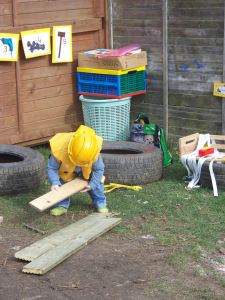 Child playing in the garden with toys